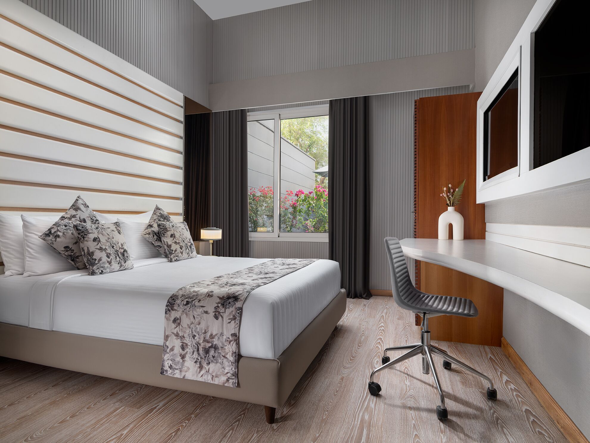 A modern bedroom with a bed, a desk, and a chair.