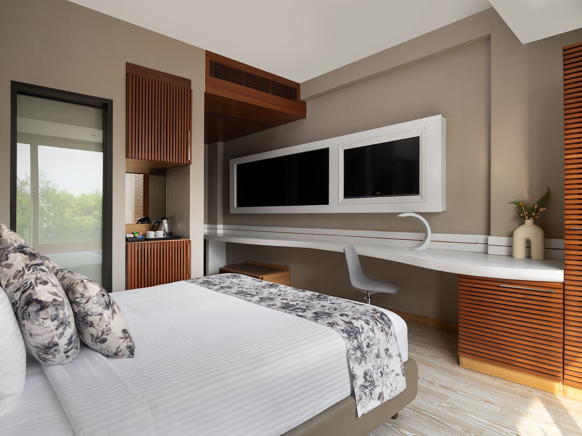 Une chambre à coucher moderne avec un lit, un bureau et un téléviseur.