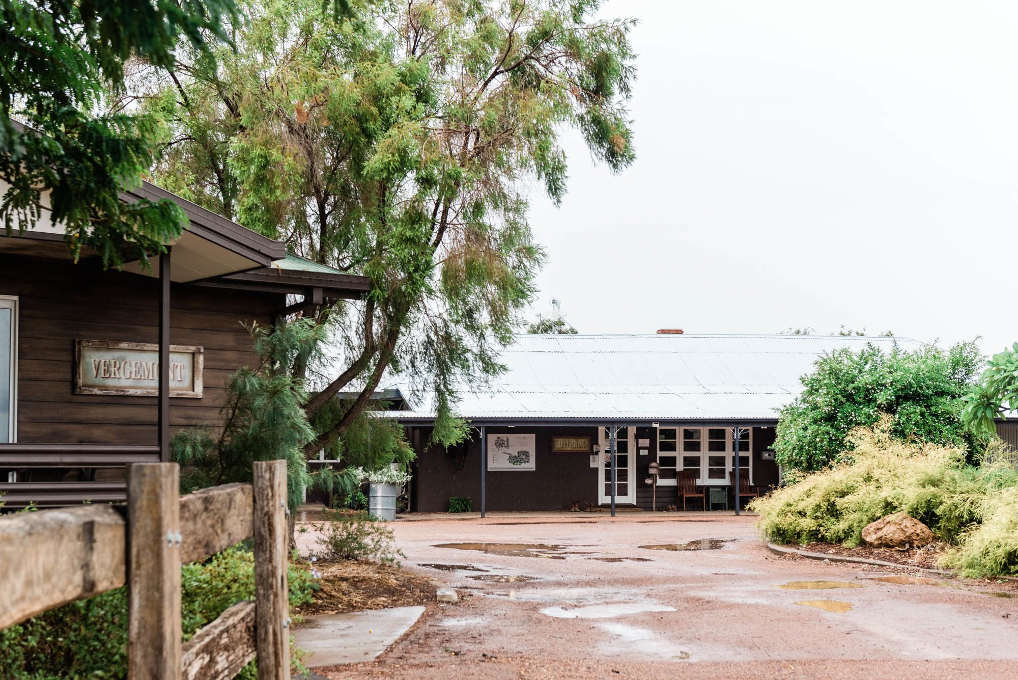 A rustic building with a wooden facade, a sign reading "VERGEMENT," and a covered entrance.
