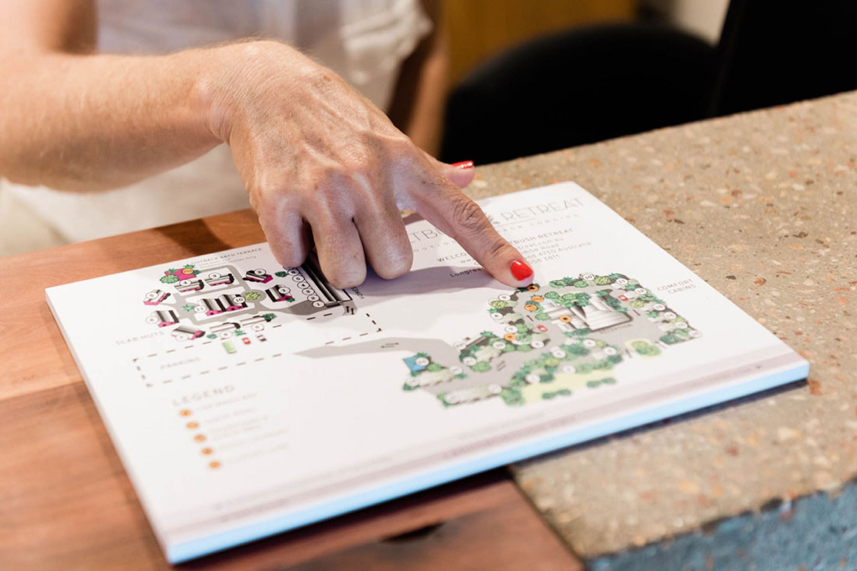 A person pointing at a map on a booklet.