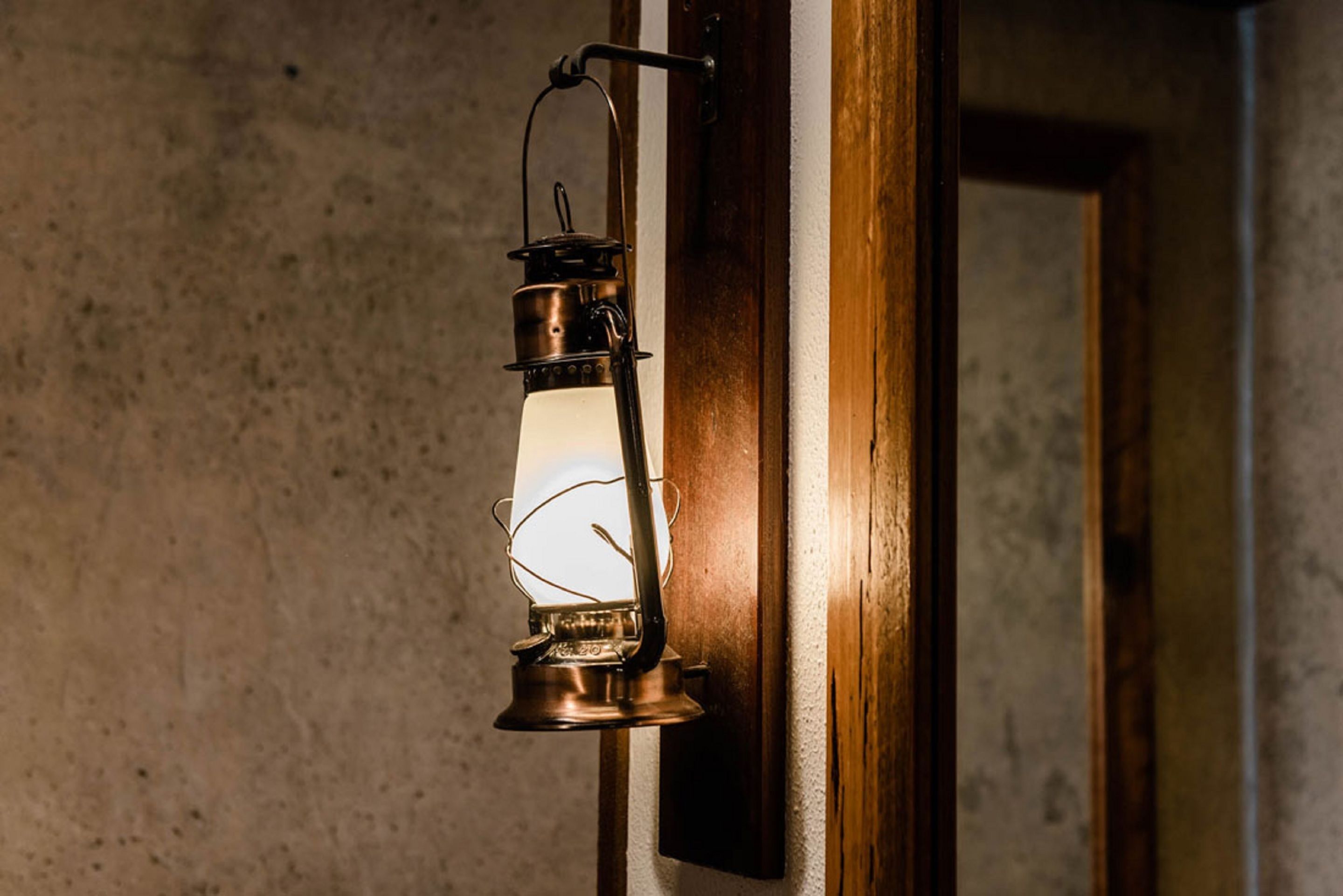 A vintage-style lantern mounted on a wooden door frame.