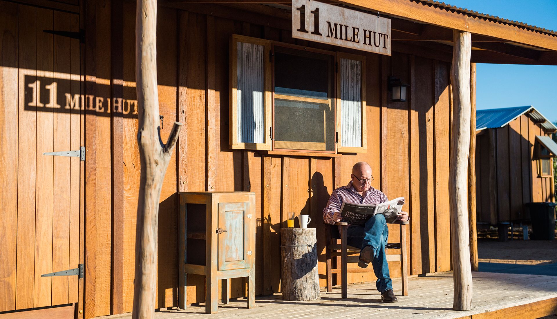 Una cabaña de madera con un letrero que dice "11 Mile Hut".