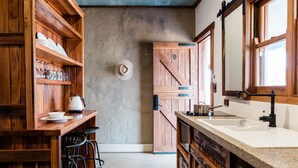 Une cuisine avec des meubles de rangement en bois, un évier et une cuisinière.
