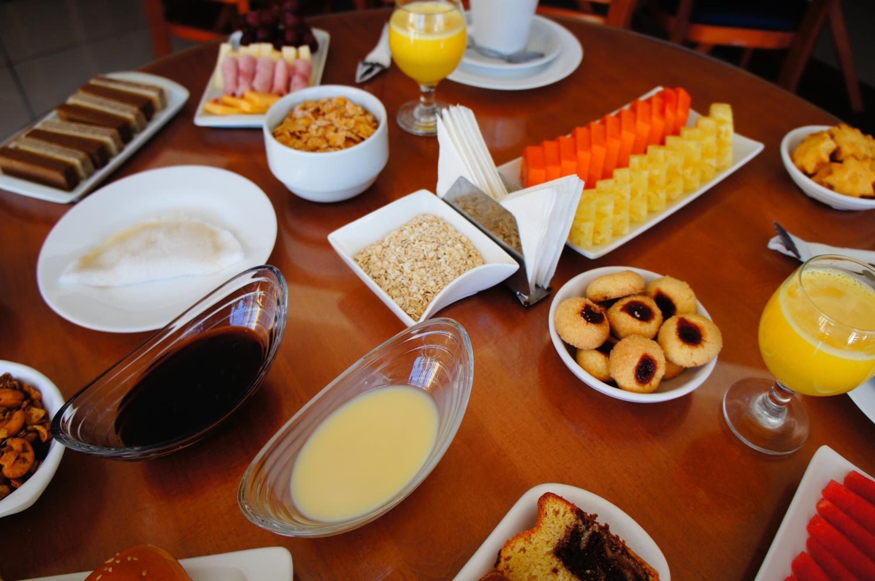 A breakfast buffet with various dishes, including pastries, fruits, and beverages.