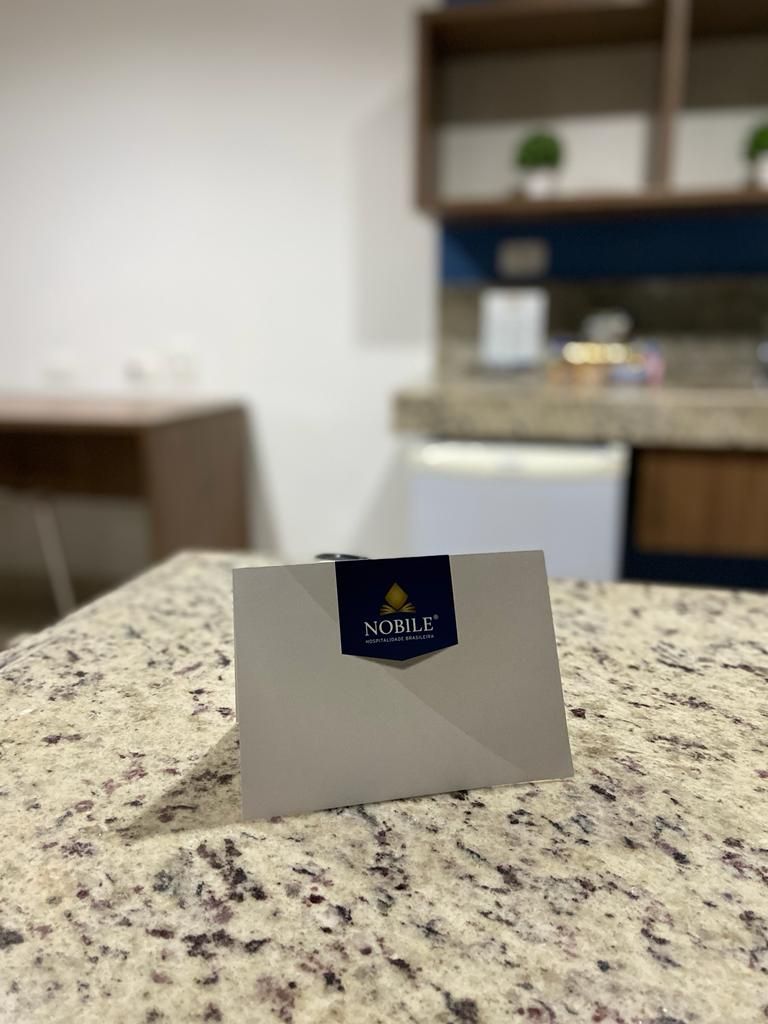 A business card on a granite countertop with a kitchen in the background.