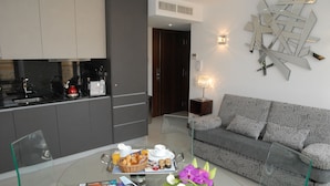 Una sala de estar moderna con una mesa de centro de vidrio, un sofá y un elemento decorativo en la pared.