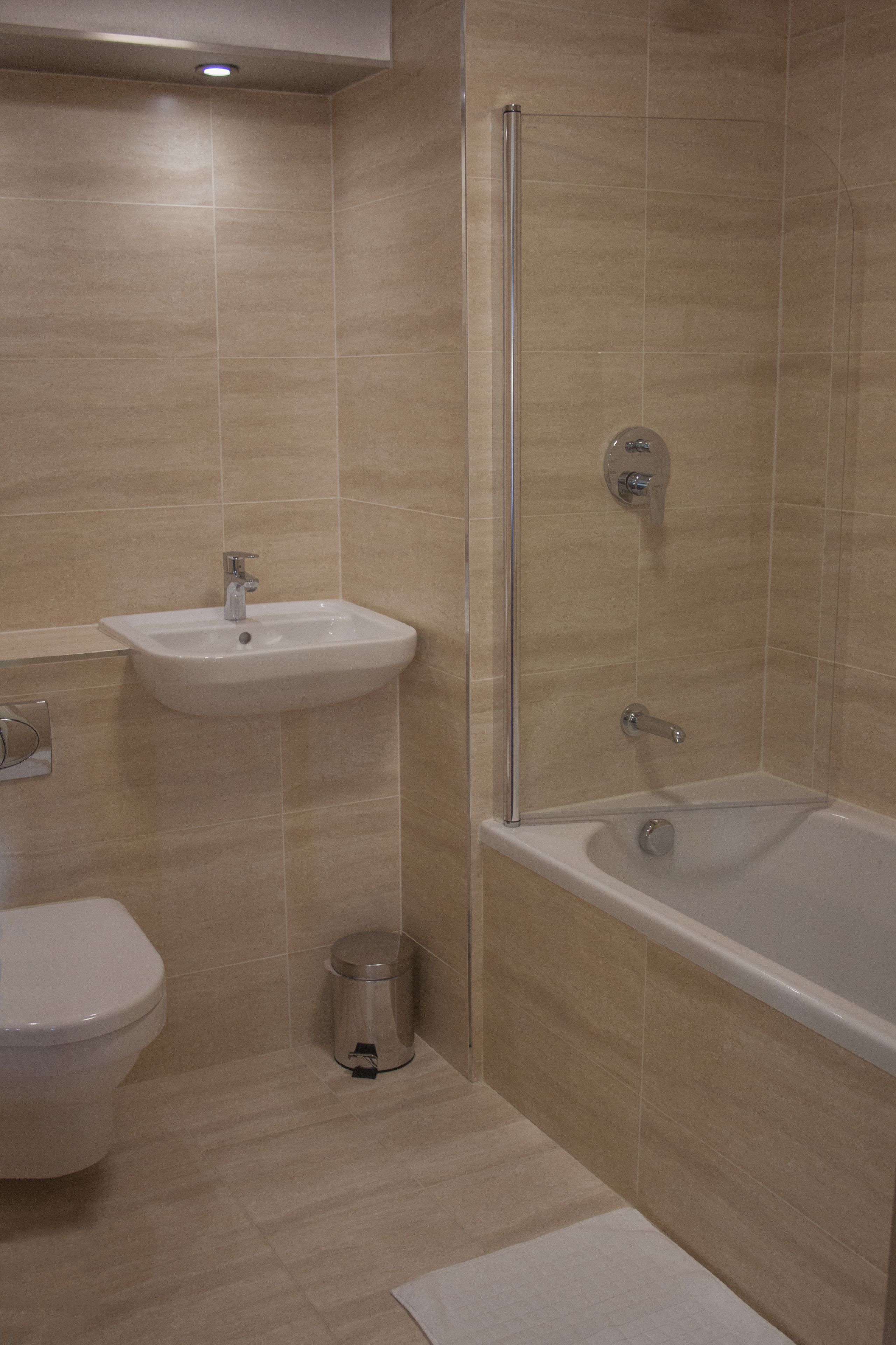 A bathroom with a toilet, sink, and bathtub.