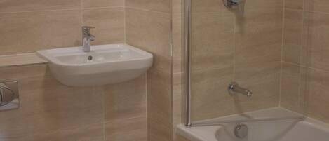 A bathroom with a toilet, sink, and bathtub.