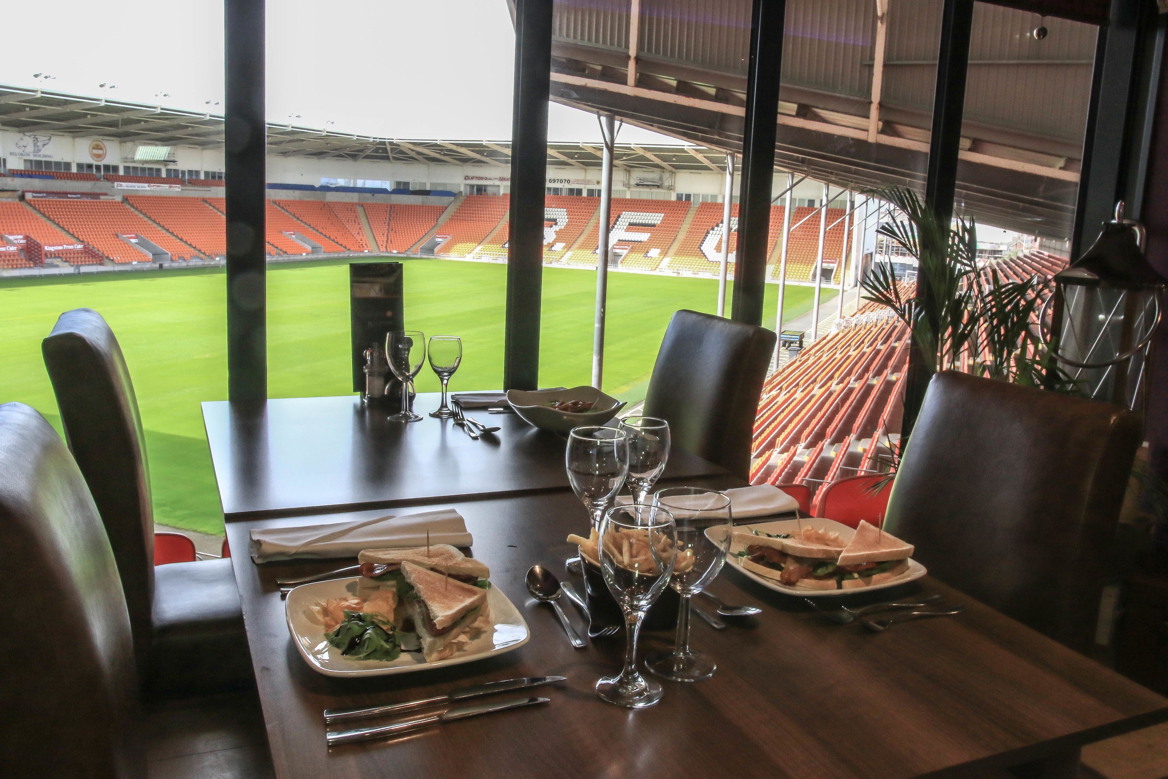 Een eettafel met uitzicht op een stadion.