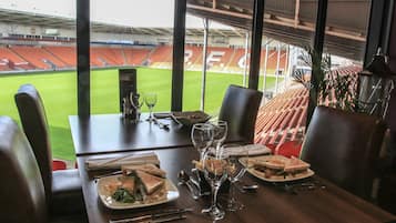 Een eettafel met uitzicht op een stadion.