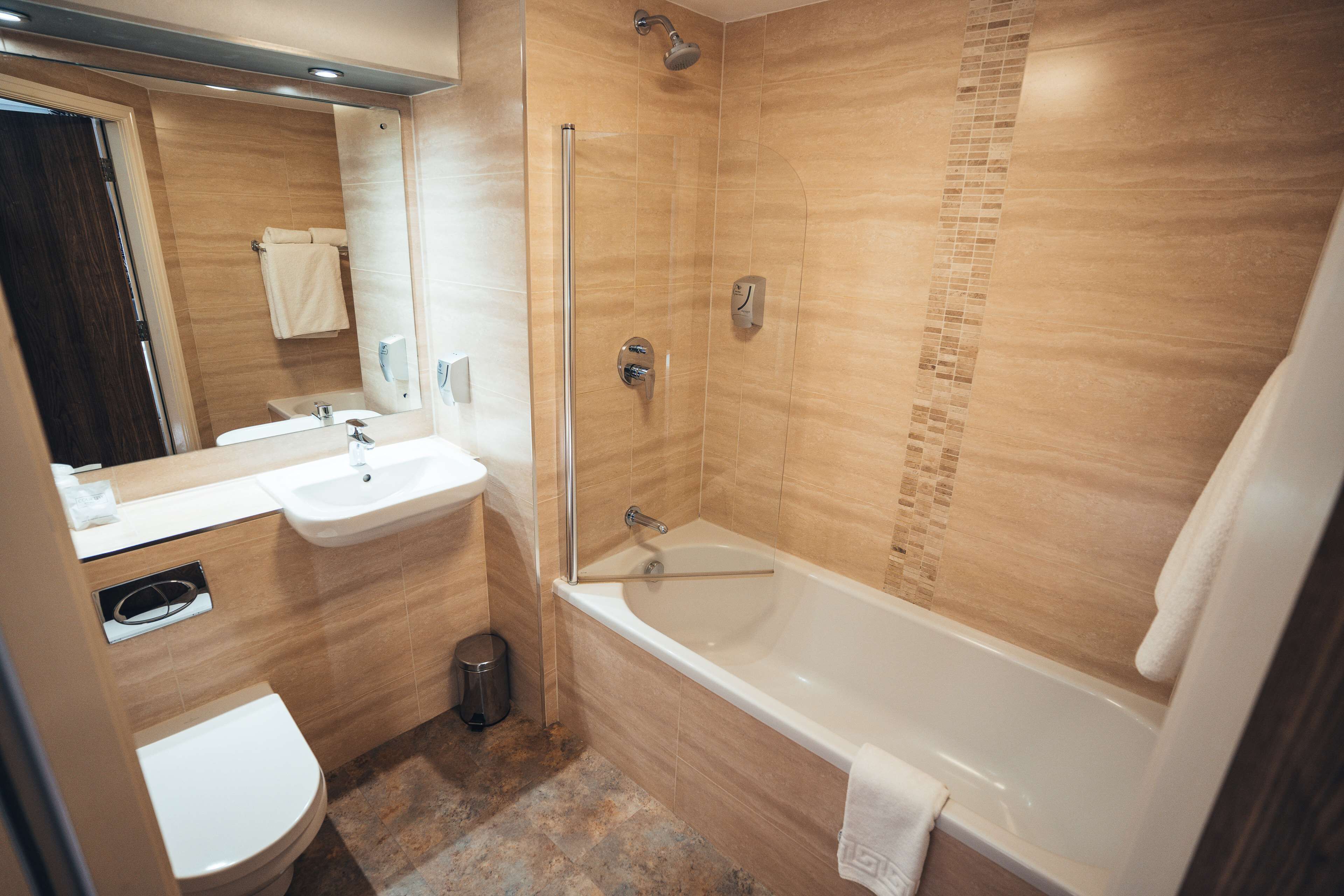 A modern bathroom with a bathtub, sink, and toilet.