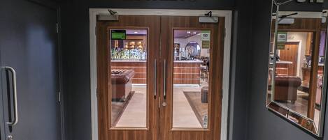 A hotel entrance with double doors, a reception area visible through the glass, and a sign above the doors reading "ROWLEYS".