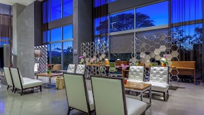 A modern interior with seating arrangements, a decorative wall, and large windows.