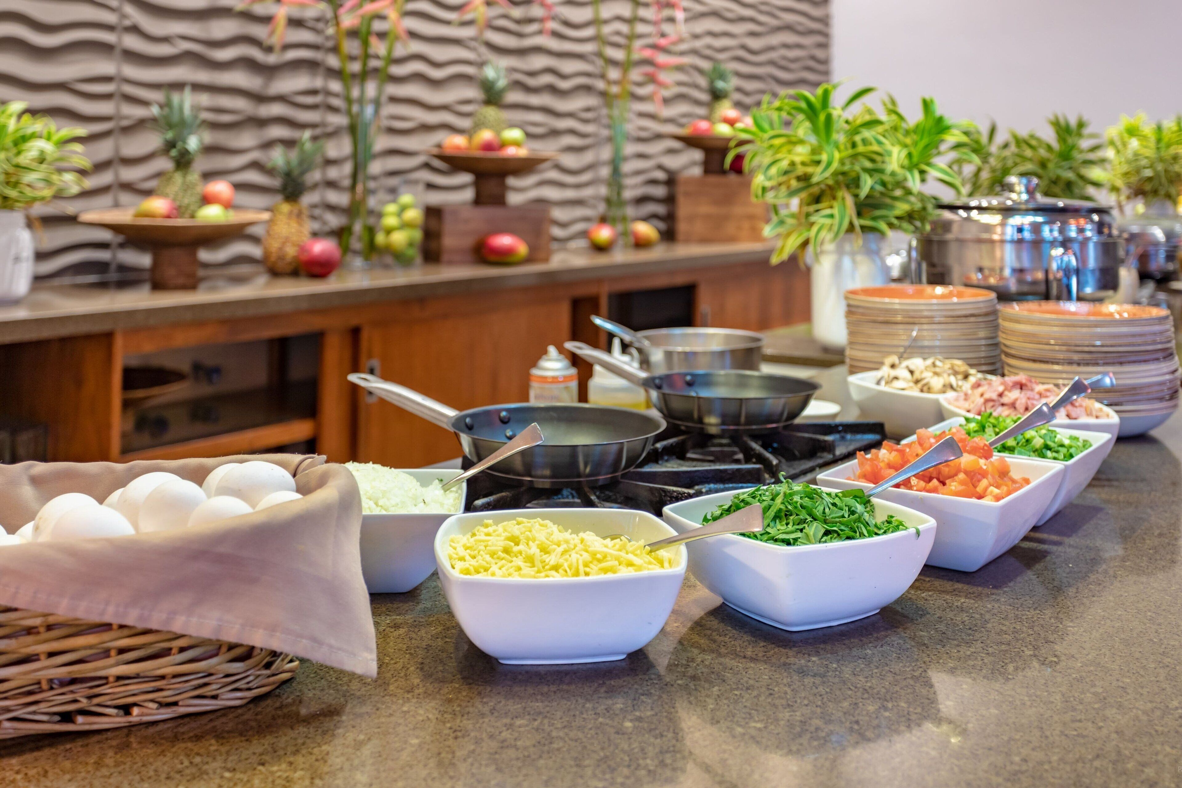 A buffet setup with various food items and kitchen equipment.