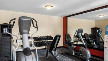Een sportschool met loopbanden, gewichten en trainingsapparatuur.