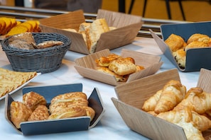 A variety of baked goods displayed in wooden boxes and a wicker basket.