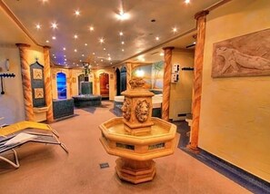 A lobby with a central fountain, columns, and a seating area.