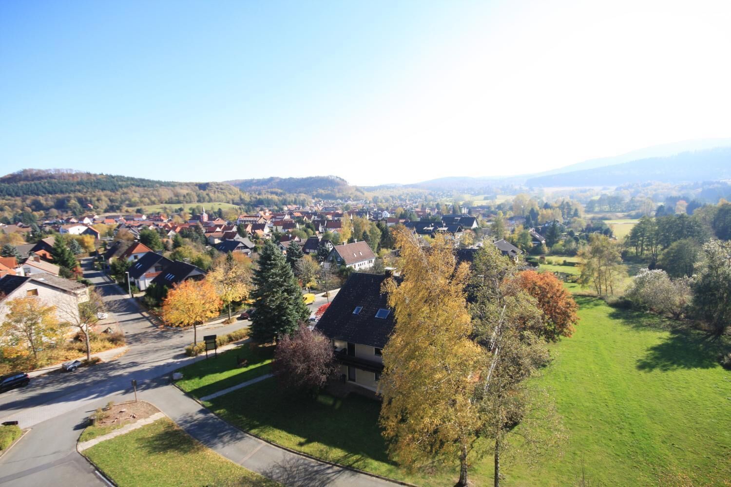 Ein Wohngebiet mit Häusern, einer Straße und grünen Feldern.