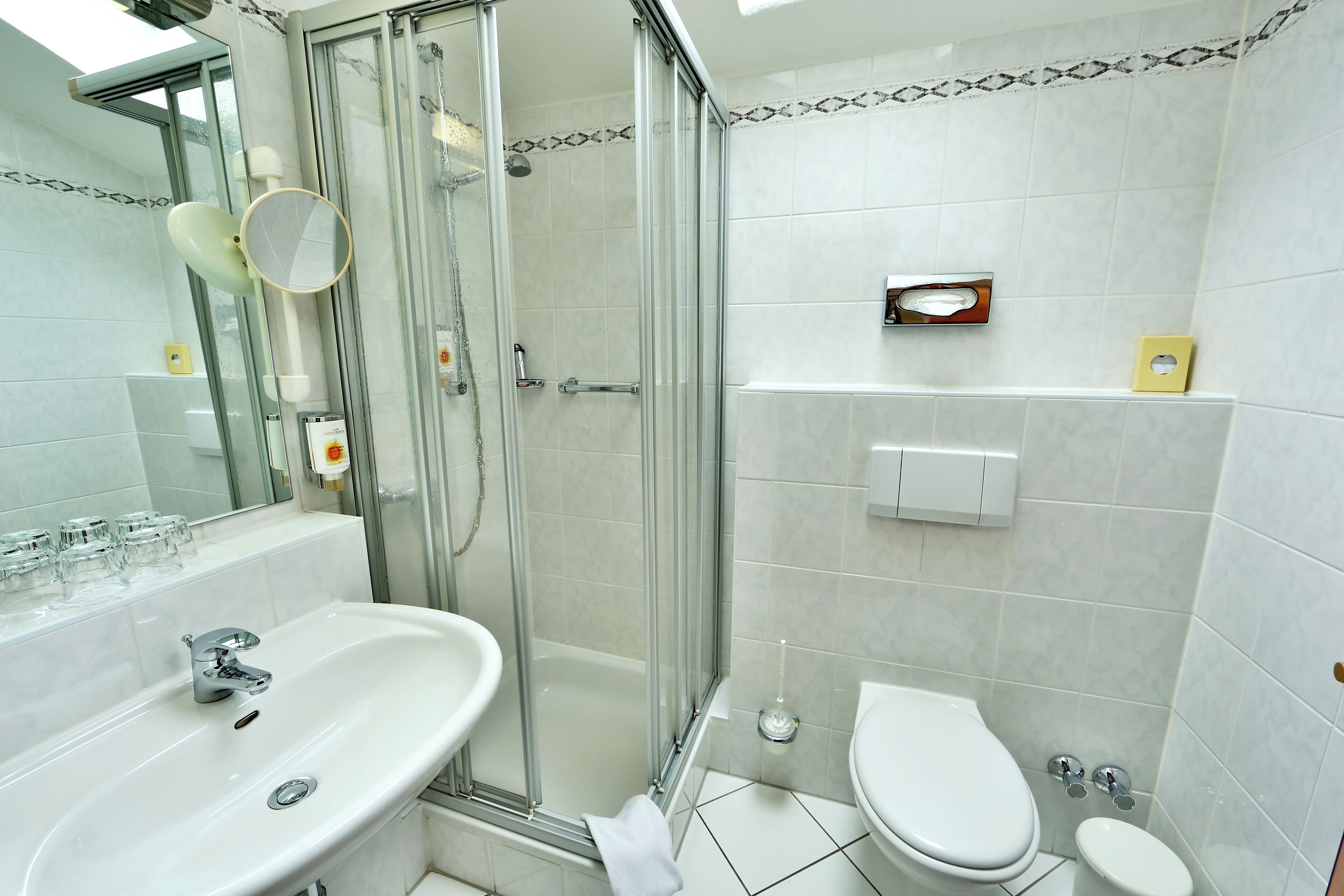 Une salle de bain moderne avec une douche à parois de verre, un lavabo et des toilettes.