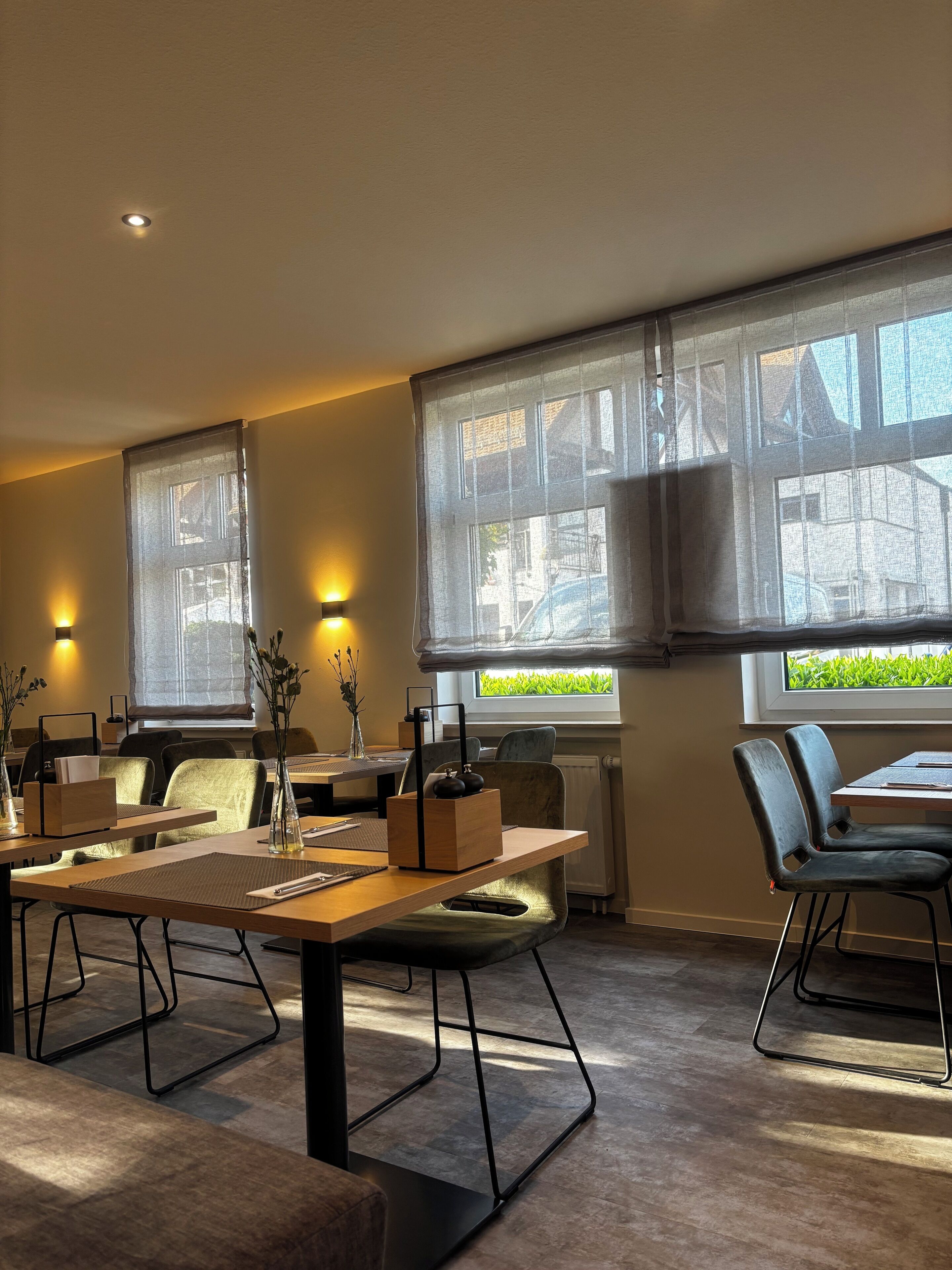 A modern conference room with large windows, a wooden table, and comfortable seating.