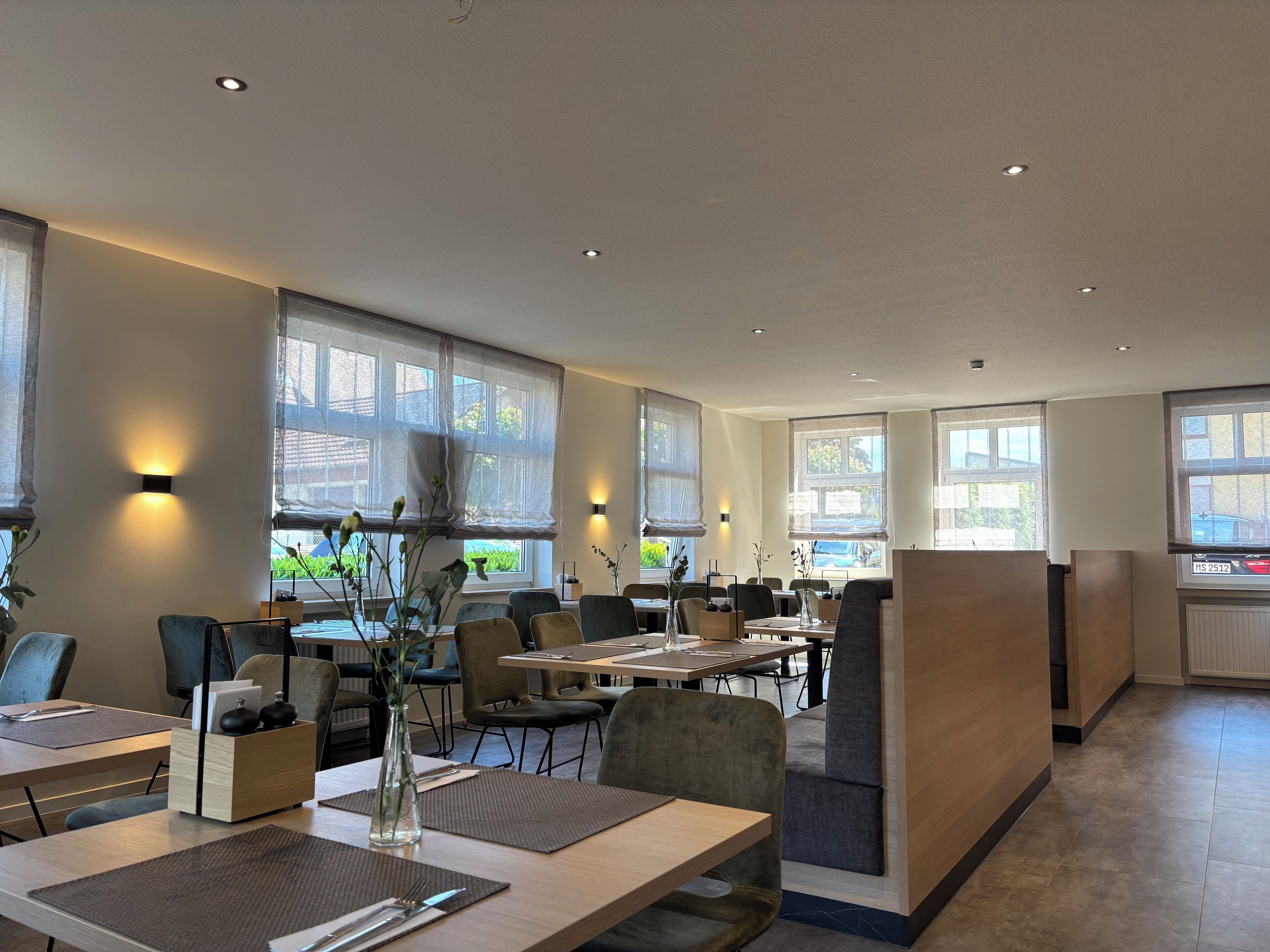 A modern dining area with tables, chairs, and a central decorative vase.