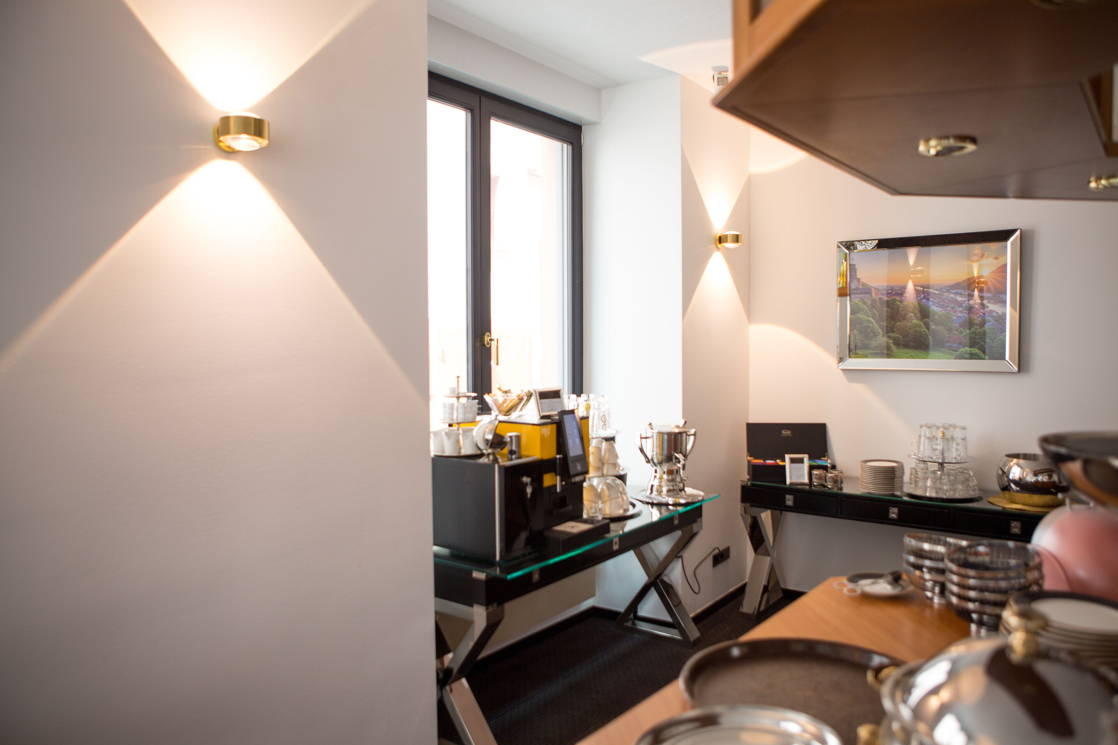 Eine moderne Küche mit Kaffeemaschine, Gläsern und einem gerahmten Bild an der Wand.