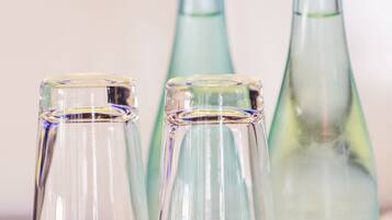Three clear glass bottles of varying sizes on a yellow surface.