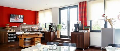 Quarto de hotel moderno com área de refeições, cozinha e grandes janelas.