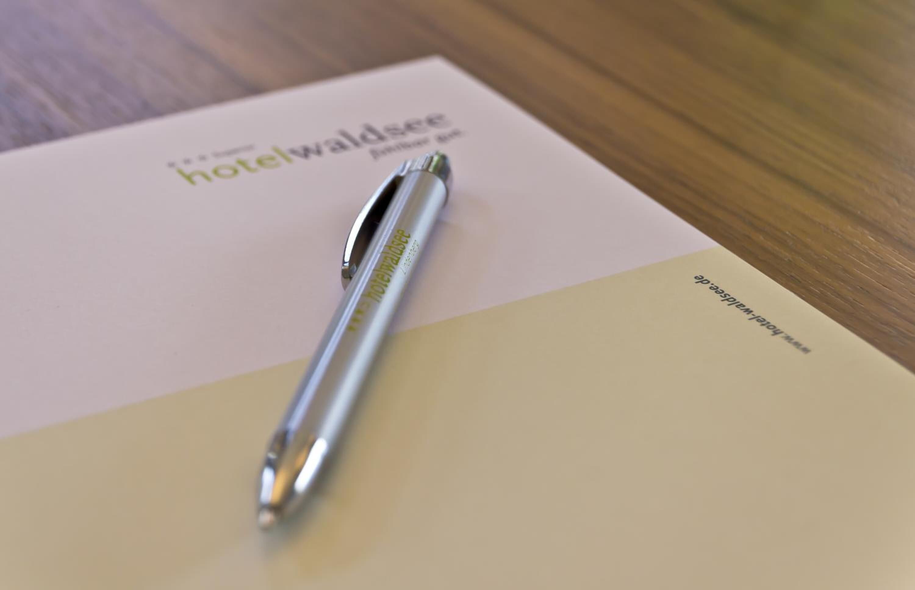 A pen on a booklet with the text "hotelwaldsee" and "Hotel Waldsee."