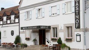 Un hotel llamado 'Hotel Gasthof Krone' con terraza al aire libre y jardineras con flores.