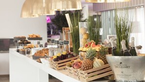 Un bufé con diversas frutas, pasteles y botellas de champán.