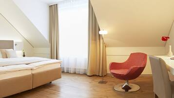 Una habitación de hotel moderna con cama, escritorio, silla y televisor.