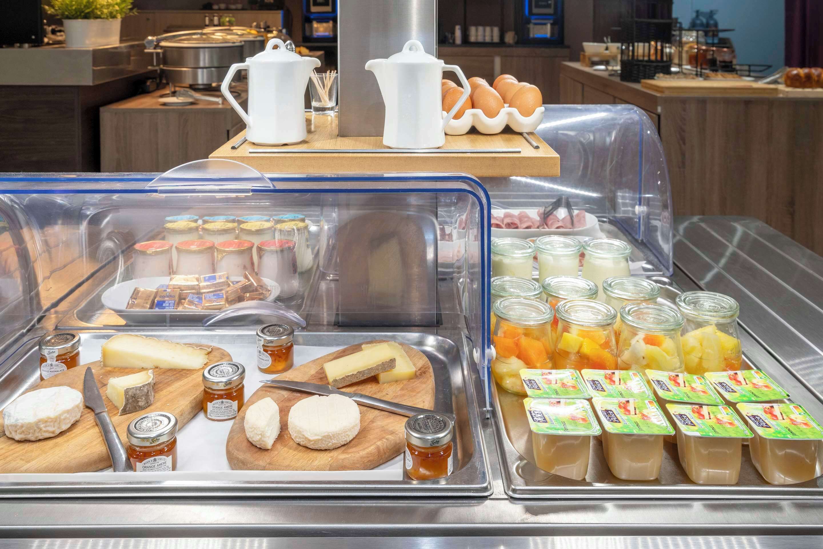Un buffet de petit-déjeuner proposant une variété de fromages, de confitures et de yaourts en verrines.
