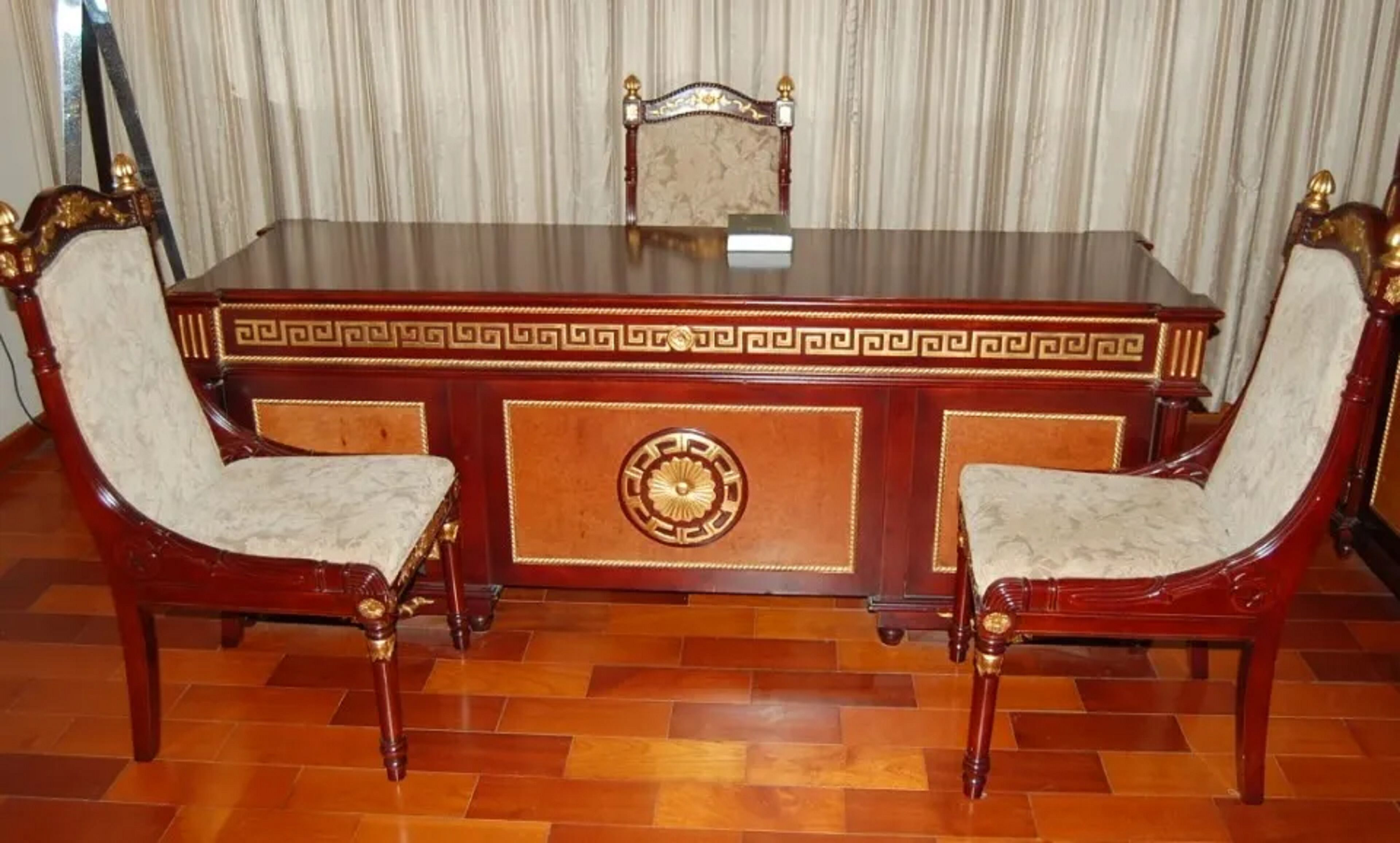 Una mesa de conferencias de madera con dos sillas, cada una con asiento y respaldo acolchados.