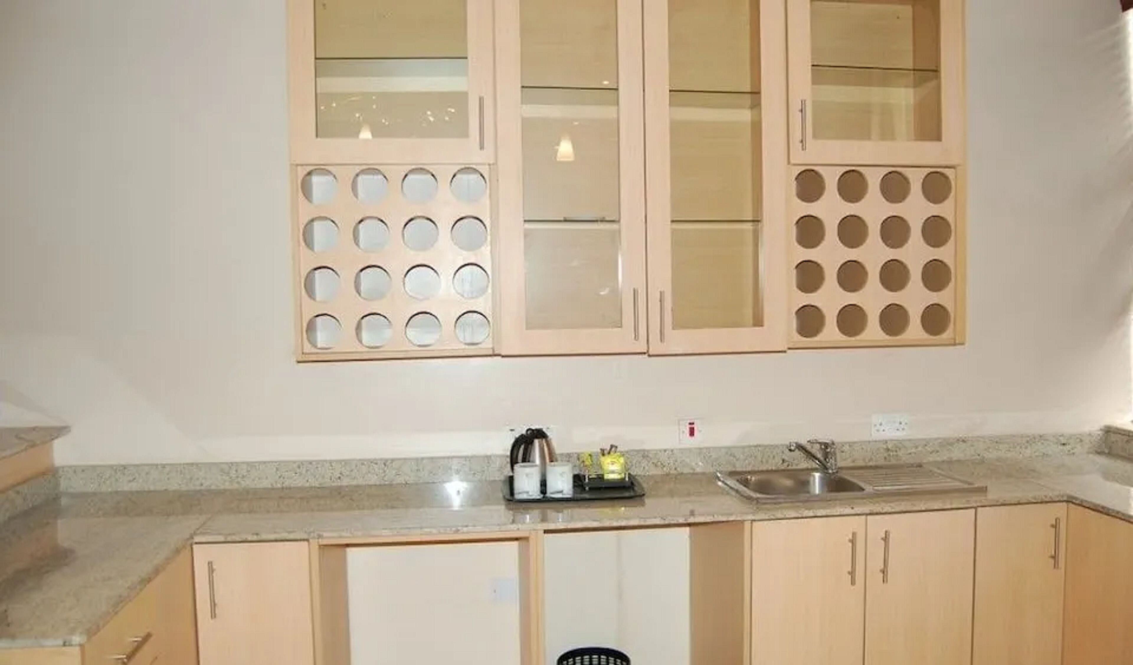 A kitchen with wooden cabinets, a granite countertop, and a stainless steel sink.