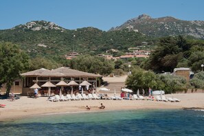 Nära stranden, solstolar, parasoller och strandhanddukar
