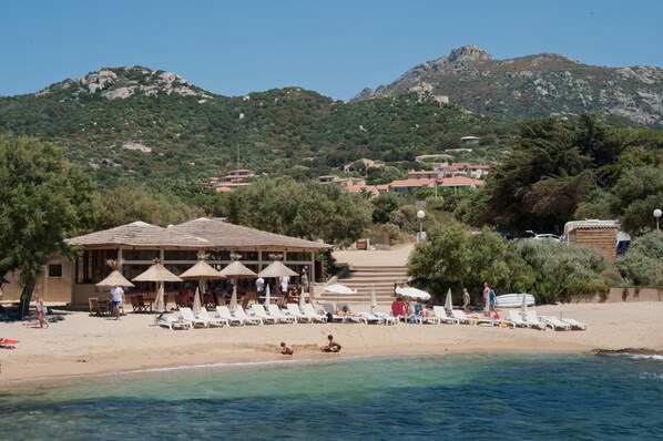 Nära stranden, solstolar, parasoller och strandhanddukar