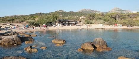 Platja a a prop, gandules de platja i para-sols per a la platja