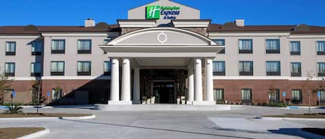 Un hotel Holiday Inn Express & Suites con entrada central, múltiples ventanas y fachada de ladrillo.