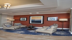 A hotel room with two sofas, a small table, and a ceiling light fixture. - Holiday Inn Express Hotel & Suites Morgan City Tiger Island by IHG (Morgan City)