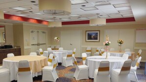 A conference room with multiple tables and chairs, equipped with ceiling lights and a carpeted floor. - Holiday Inn Express Hotel & Suites Morgan City Tiger Island by IHG (Morgan City)