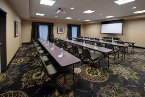A conference room with long tables, chairs, water bottles, and a projector screen. - Holiday Inn Express Hotel & Suites Clearfield by IHG (Clearfield)
