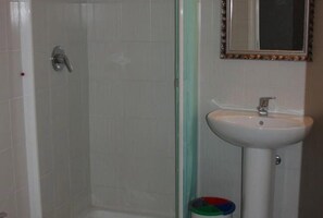 Habitación estándar con 1 cama matrimonial o 2 individuales | Baño | Regadera, regadera tipo lluvia, amenidades de baño gratuitas 