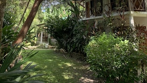 A house surrounded by lush greenery, with a well-maintained lawn and various plants. - Hotel Jaguar Inn Tikal (Flores)