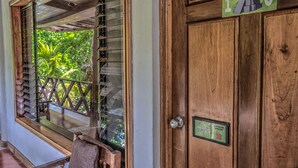 A wooden door with a window and a sign indicating room number 1C. - Hotel Jaguar Inn Tikal (Flores)