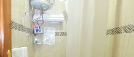 A bathroom with a toilet, shower, and sink.