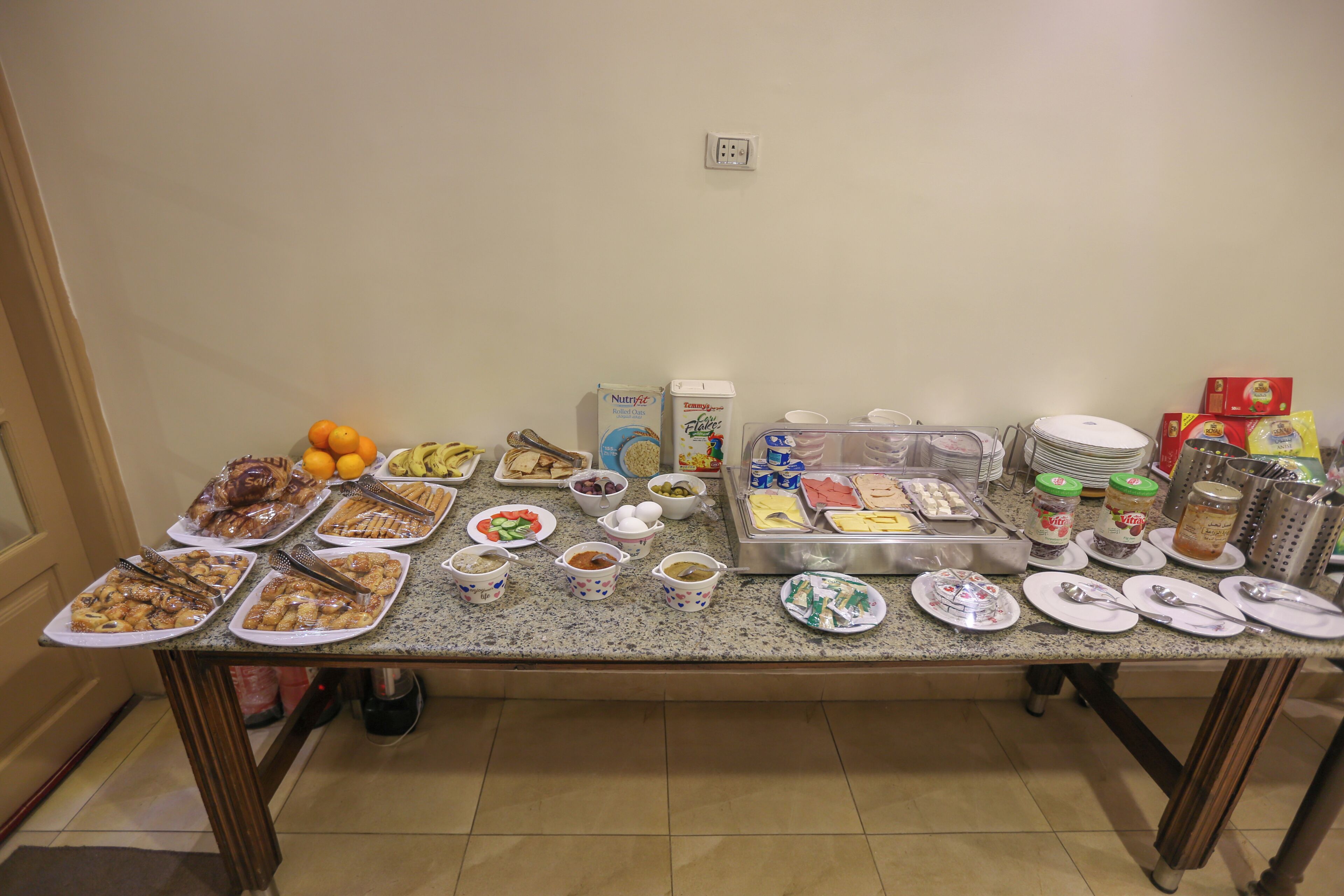 A buffet table with various food items and utensils.