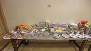 A buffet table with various food items and utensils.