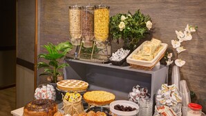 A buffet table with various food items, including cakes, pastries, and condiments. -  Dharma Luxury Hotel & Spa. (Rome)