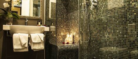 Une salle de bain moderne avec une douche à parois de verre, un lavabo blanc et un miroir.